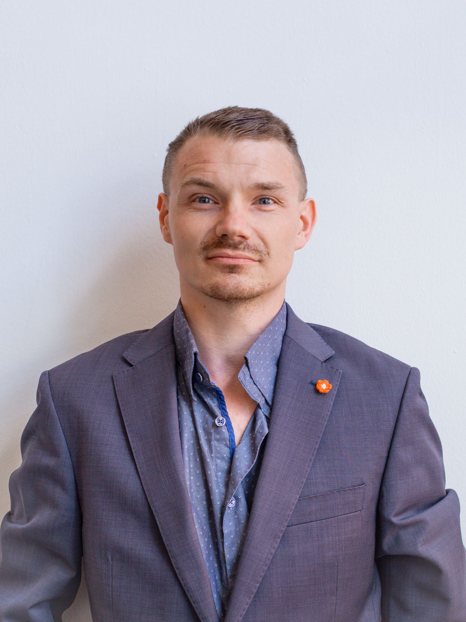 Medwerker foto van Niels - blauwe ogen, kort blond haar en in pak.